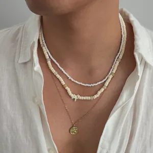Close-up detail shot of multi-layer beaded beach starfish necklace with gold pendant.