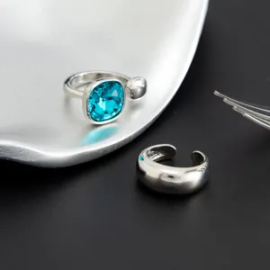 Primer plano del conjunto de anillos de dedo del pie ajustables con cristal azul y liso.