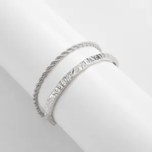 Close-up detail of men's silver tone textured cuff bracelet and stylish twist chain set.