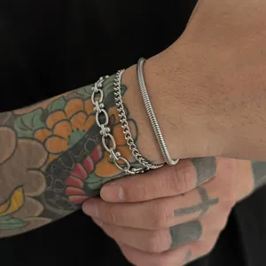 Detail van minimalistische roestvrijstalen stapelbare armbandset voor heren, hippe trendy.