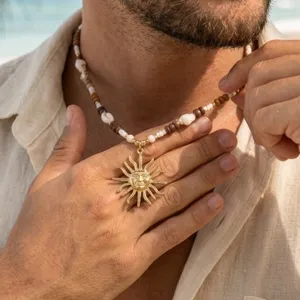 Elegante collana da uomo in conchiglie e cocco stile boho con pendente viso sole dorato.