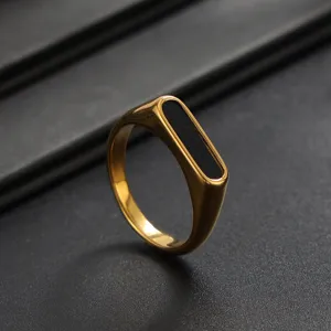 Gold stainless steel signet ring detail showcasing smooth polished finish and black inlay.