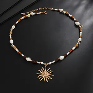 Primo piano dettagliato della collana di perline in guscio di cocco boho con ciondolo sole.