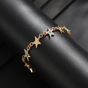 Gedetailleerd close-upoverzicht van de gouden sterrenketting met sprankelende blauwe kristalstenen.