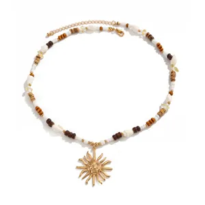 Collana di perle con sole boho con perline di legno, conchiglie bianche e cristalli estivi.