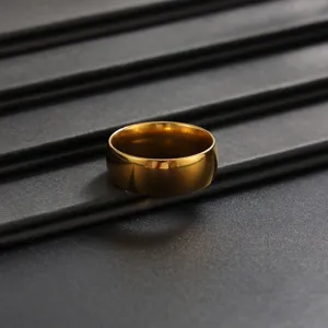 Gros plan de détail d'une bague anneau unie dorée minimaliste sur fond sombre texturé.