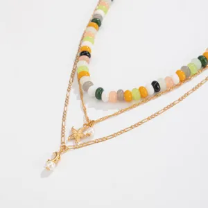 Primo piano dettagliato della collana di perle multicolore multistrato con pendenti stella.