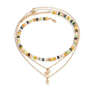 Collana di perle colorate multistrato con catena dorata e ciondolo stella marina.