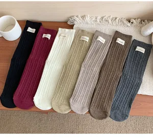 Detailweergave van gekleurde geribbelde katoenen sokken met geweven labels in gezellige stijl.