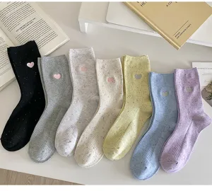 Detailed view of cute heart embroidered cotton socks with colorful flecks, soft cozy fabric.
