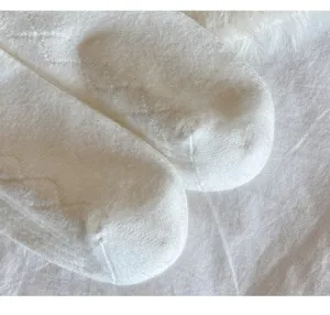 Detailaufnahme von weichen weissen Damen Kaschmir Ueberkniestruempfen, gemuetliche Winter Textur.