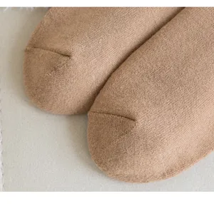 Nahaufnahme weicher brauner Thermostrick-Socken, dicker Frotteebaumwollstoff für den Winter.