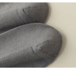 Gros plan de la pointe de chaussette en tricot gris avec des détails texturés fins.