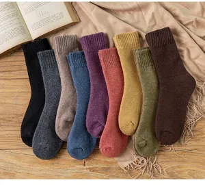 Close-up detail of multi-color thick winter wool socks displayed neatly on cozy fabric.