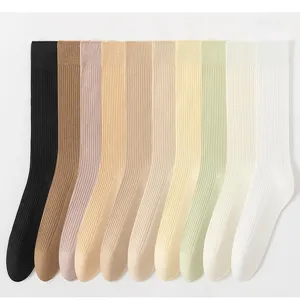 Close-up detail van geribbelde sokken tot halverwege de kuit in diverse pastelkleuren.