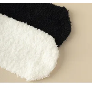 Close-up detail of thick fuzzy coral fleece thermal floor socks in black and white colors.