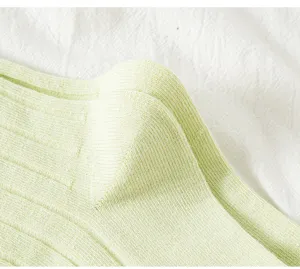 Nahaufnahme der hellgrünen gerippten Stricksocken mit weicher Textur und feiner Webart.