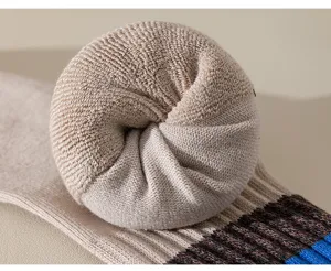 Close-up view of thick looped towel bottom and colorful striped cuff of men's winter athletic socks.