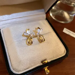 Exquisite floral stud earrings with dazzling zirconia and elegant gold finish in box.