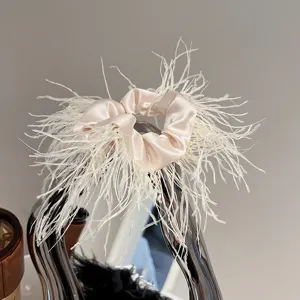Detailed close-up view of the stylish ostrich feather satin hair scrunchie accessory.