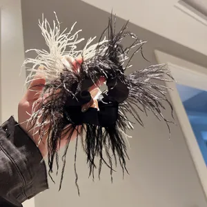 Ostrich feather hair scrunchie detail view, black and white fluffy hair accessory.