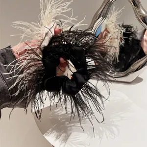 Close-up fluffy black and white ostrich feather hair scrunchy detail view, chic fashion accessory.