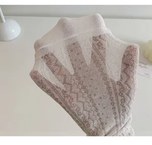 Detail view of sheer white lace mesh socks, showing high elasticity and breathable texture.
