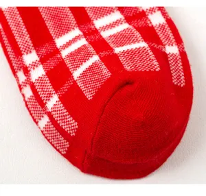 Detaillierte Nahaufnahme der feinen Stricktextur von der roten Karomuster Socke.