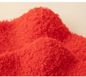 Close-up detail of soft red coral fleece fabric for winter thermal socks and cozy apparel.