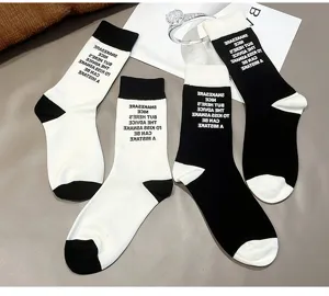 Trendy black and white color block cotton mid-tube socks with stylish letter print for women.