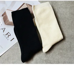 Nahaufnahme von schwarzen und weißen gerippten Baumwollsocken mit weicher Textur.