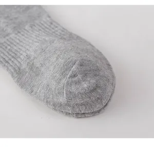 Primo piano della punta del calzino in cotone grigio con trama a maglia fine e cucitura pulita.