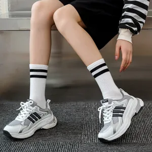 Calze a righe bianche e nere in stile coreano abbinate a scarpe da ginnastica alla moda.