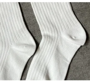 Detailansicht von weißen gerippten Socken mit feiner Textur und elastischem Bündchen.