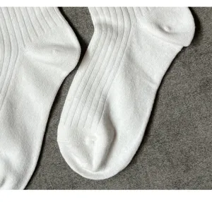 Nahaufnahme von weißen gerippten Socken mit elastischer Strickstruktur und weichem Material.