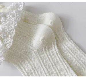 Detailed view of white Lolita lace socks with cute ruffles and hollow knit design for girls.