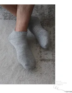 Detalle en primer plano de calcetines deportivos grises de algodón en el pie, tejido transpirable.
