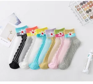 Closeup of colorful sheer summer crystal socks with cute daisy pattern and ribbed cuff design.