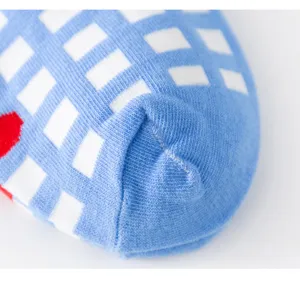Gros plan détaillé de la chaussette de cheville en coton bleu clair à motif carreaux.