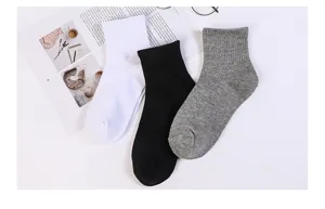 Vue détaillée de chaussettes courtes unies en coton blanc, noir et gris, douces et confortables.