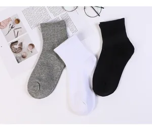 Chaussettes unies en coton mi-haut pour hommes et femmes, respirantes et confortables au quotidien.