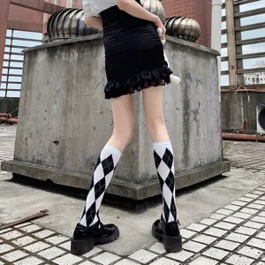 Vue rapprochée des chaussettes montantes classiques à motif losanges noir et blanc.