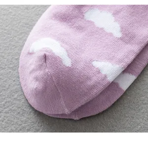 Close-up detail of purple cotton socks featuring cute white cloud patterns for women and girls.