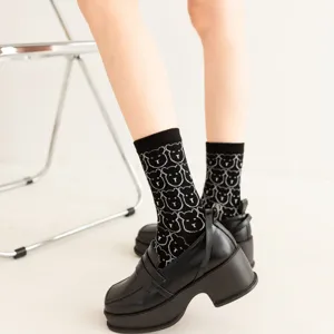 Chaussettes mi-mollet noires mignonnes pour femmes avec un motif dours blanc élégant et doux.