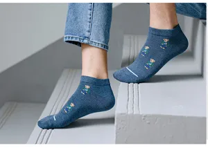Detail shot of men casual short cotton socks featuring cute teddy bear pattern on steps.
