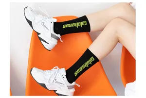 Damen Streetwear Wadenlange schwarze Socken mit grünem Buchstabenprint Detailansicht.