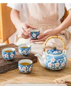 Blue and white ceramic tea set with teapot and four cups, featuring plum blossom design.