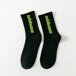 Schwarze Mittelsocken mit neongrünen Calabasas Buchstaben, Streetwear Trend Skater Socken.