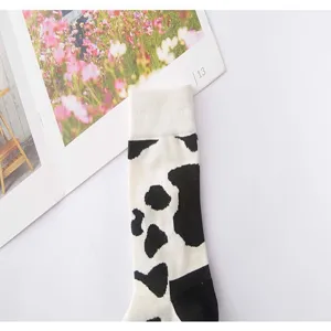 Nahaufnahme von schwarz-weißen Kuhmuster Baumwoll Socken im lässigen Streetwear Stil.