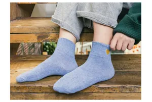 Vue détaillée de chaussettes courtes en coton bleu clair avec broderie cœur doré.